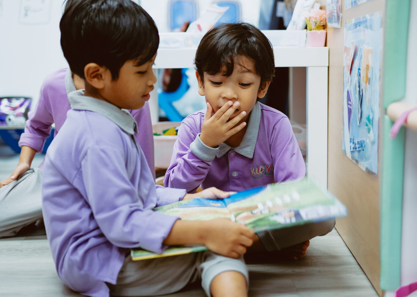 Two children reading together at Kidya Childcare