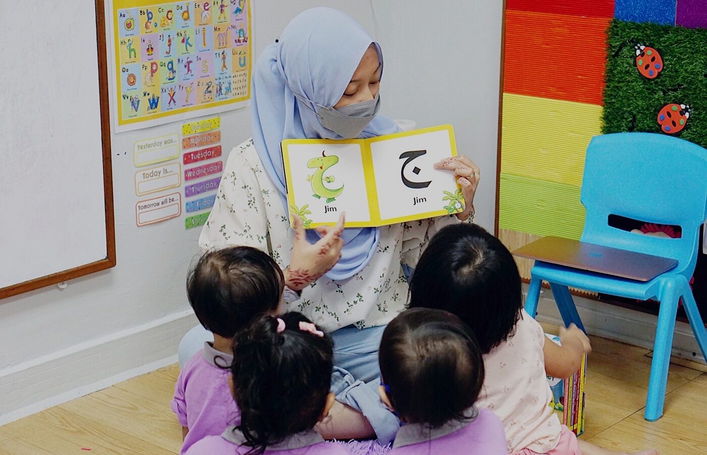 A teacher reading an Arabic book with children at Kidya Childcare