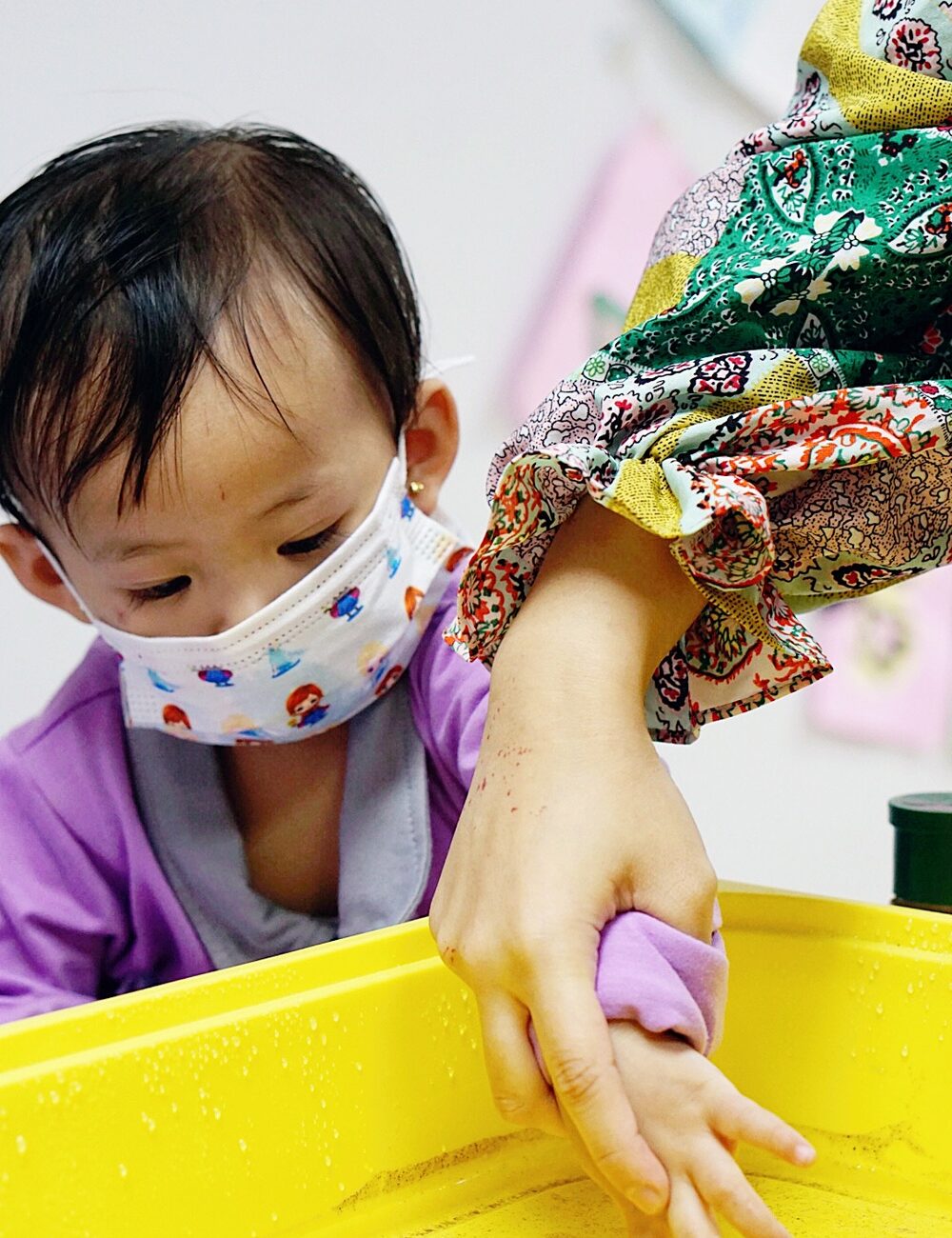 A toddler exploring a sensory tray at Kidya Childcare