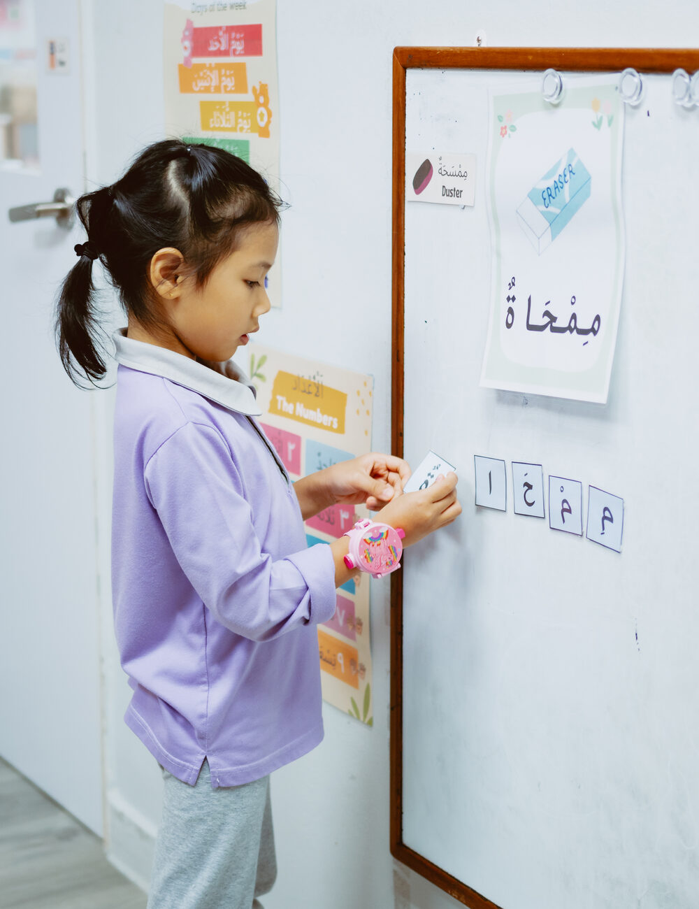 A child arranging Arabic word cards on the board at Kidya Childcare