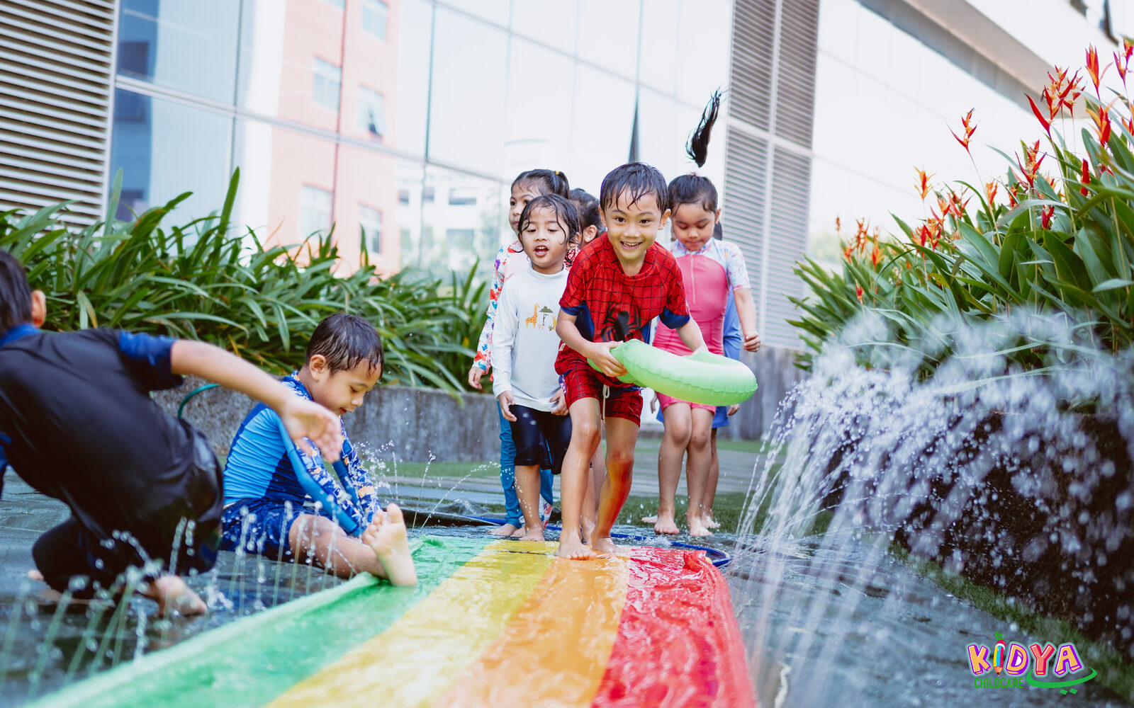 Children running through the water play at Kidya Childcare