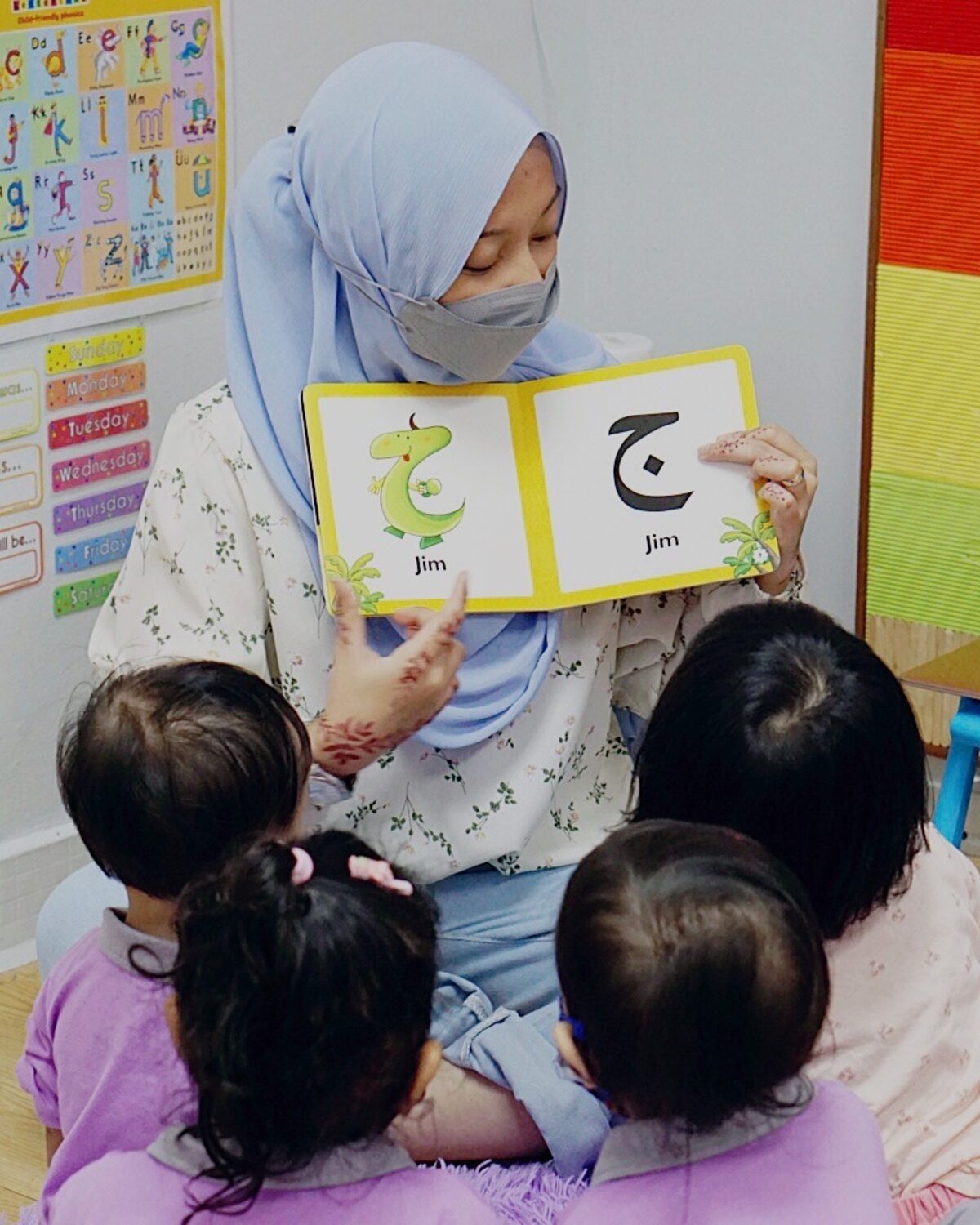 A teacher reading with children at Kidya Childcare
